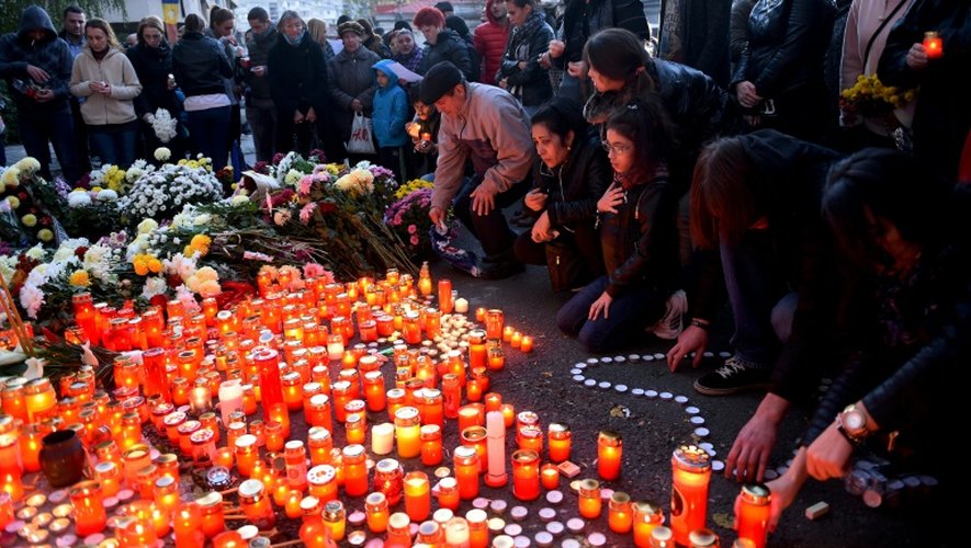 Des personnes disposent des bougies en hommage aux victimes de l'incendie dans la discothèque à Bucarest,  le 31 octobre 2015
