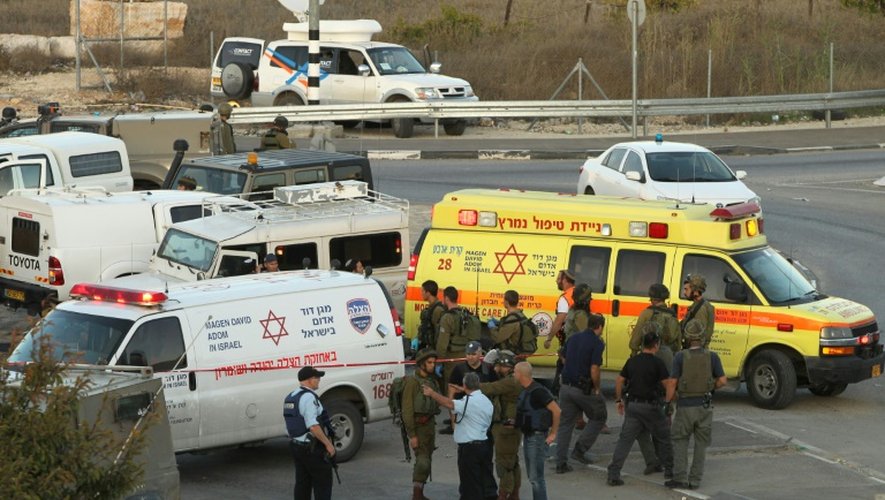 Les forces de sécurité israéliennes et les secours sur les lieux d'une attaque à la voiture bélier  contre des garde-frontières israéliens à Beit Einoun, au nord d'Hébron le 1er novembre 2015, en Cisjordanie