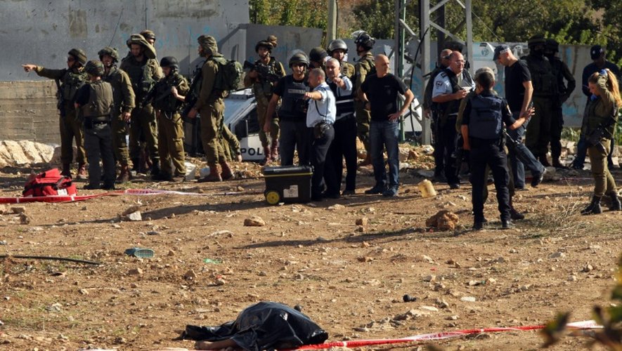Les forces de sécurité israéliennes à côté de la dépouille d'un homme tué alors qu'il tentait d'attaquer un soldat israélien près d'Hébron, le 1er novembre 2015
