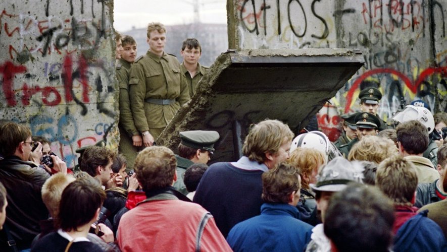 Des Allemands de l'Ouest à Berlin le 11 novembre derrière le mur alors que des gardes-frontières est-allemands détruisent une portion du mur