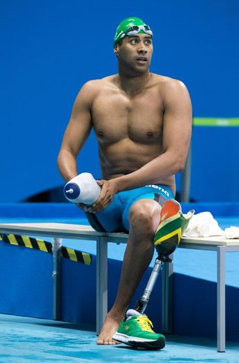 Le nageur sud-africain Achmat Hassiem retire sa prothèse aux couleurs de son pays avant de participer au 100 m nage libre (S10), le 13 septembre 2016 à Rio lors des Jeux paralympiques