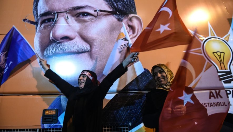 Des supportrices fêtent la victoire du parti de la Justice et du Développement aux législatives devant un portrait du Premier ministre turc Ahmet Davutoglu, le 1er novembre 2015 à Istanbul