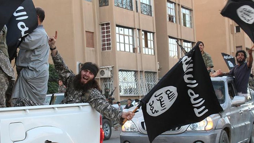 Image fournie par le média jihadiste Welayat Raqa le 30 juin 2014 montrant des jihadistes du groupe Etat islamique paradant dans une rue de la ville syrienne de Raqa