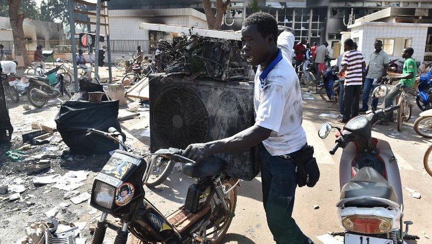 Des habitants de Ouagadougou dans l'enceinte de l'Assemblée nationale saccagée et incendiée la veille, le 31 octobre 2014 au Burkina Faso