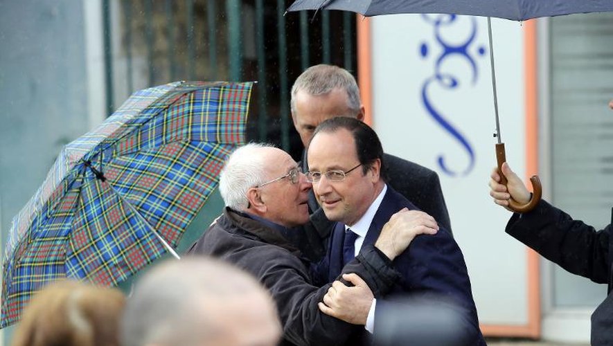 Le président de la République française François Hollande chaleureusement salué par un habitant de Tulle le 23 mars 2014