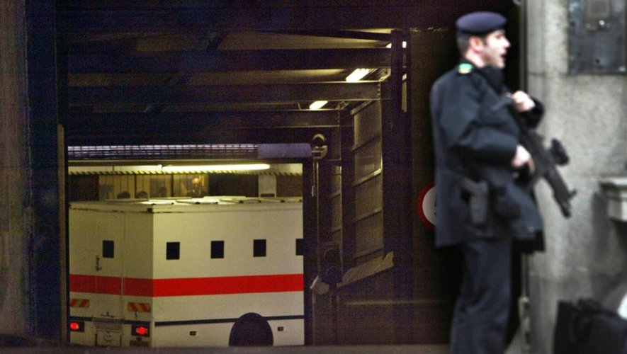 Un policier monte la garde pendant qu'un fourgon, transportant l'imam radical Abdullah al-Faisal, arrive dans un tribunal londonien, le 7 mars 2003