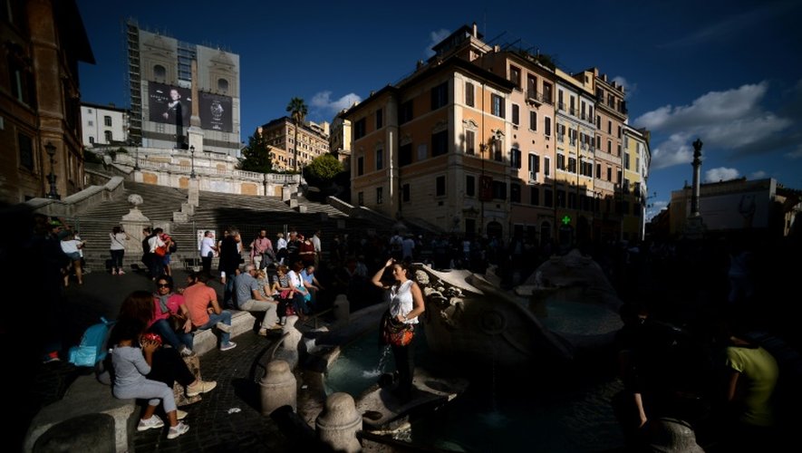 Des touristes devant la fontaine de Trevi en cours de restauration le 12 octobre 2015 à Rome