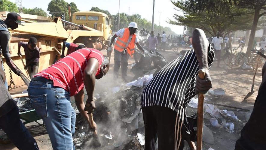 Des habitants de Ouagadougou nettoient les rues de la ville après les émeutes qui ont conduit à la démission du président burkinabè Blaise Campaoré, le 1er novembre 2014