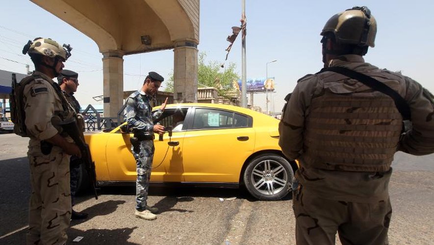 Des forces de sécurité irakiennes contrôlent un véhicule, le 17 août 2014 à Bagdad