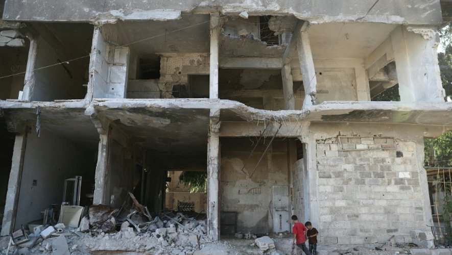Des enfants dans les ruines d'un immeuble le 14 septembre 2016 à Hamouria dans les environs de Damas