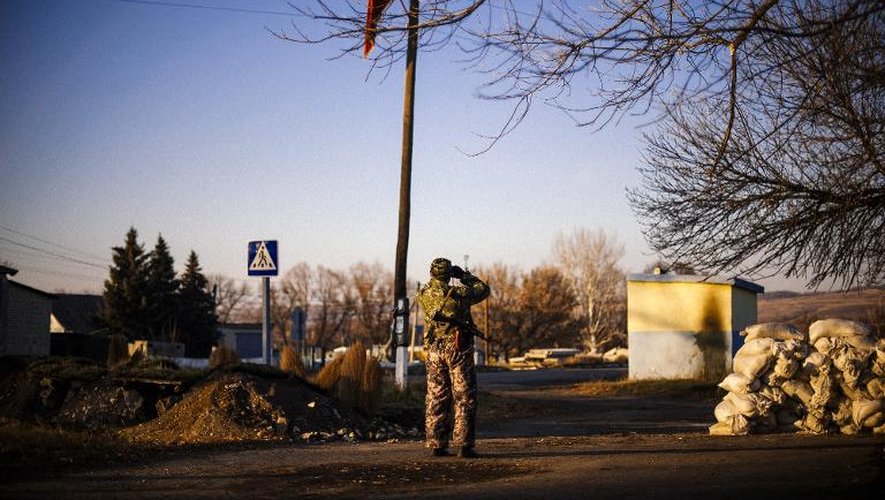 Un séparatiste pro-russe surveille les positions de l'armée ukrainienne dans un village de l'est de l'Ukraine, Frunze, le 4 novembre 2014