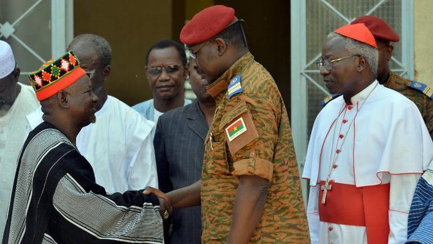 Le lieutenant-colonel Zida serre la main du roi des Mossi, le chef traditionnel du Burkina Faso, sous les yeux de l'archevêque Philippe Ouedraogo, le 4 novembre 2014 à Ouagadougou