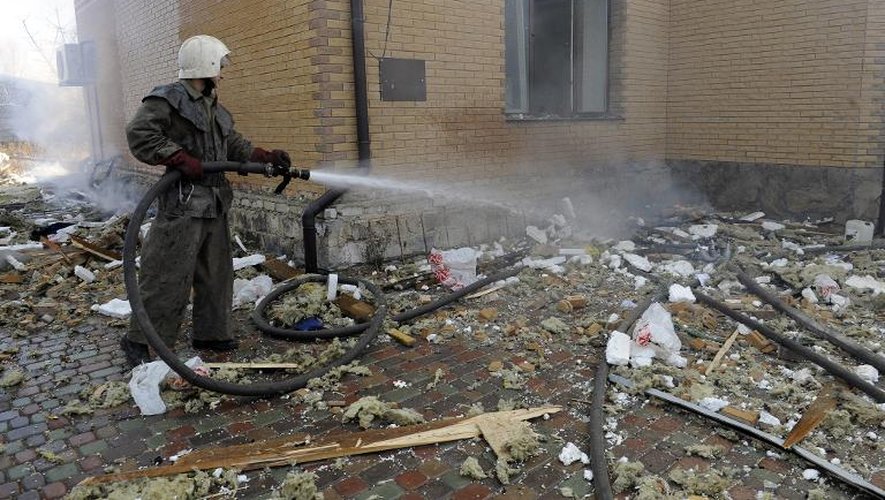 Un pompier éteint un incendie dans une maison frapppée par un bombardement à Donetsk, le 5 novembre 2014