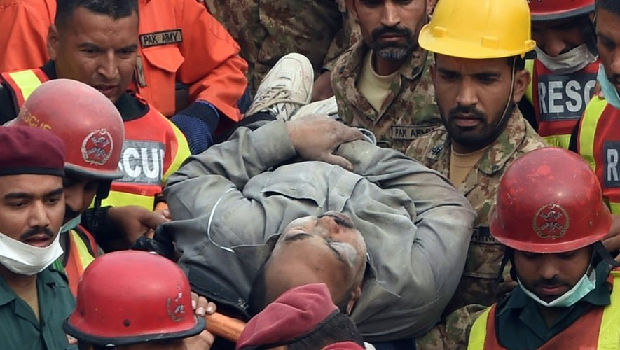 Un homme extrait des décombres par les sauveteurs le 5 novembre 2015 après l'effondrement d'une usine à Lahore