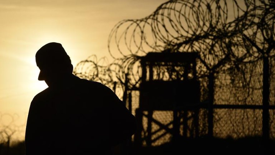 Photo realisée durant une visite guidée et visée par l'armée américaine montrant un soldat marchant près d'une barrière de  barbelés  à la prison de Guantanamo, le 9 avril 2014
