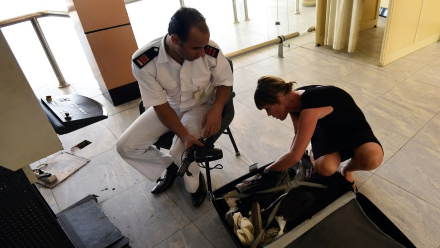 Un officier de sécurité égyptien vérifie les bagages d'une touriste britannique à l'aéroport de Charm el-Cheikh le 6 novembre 2015