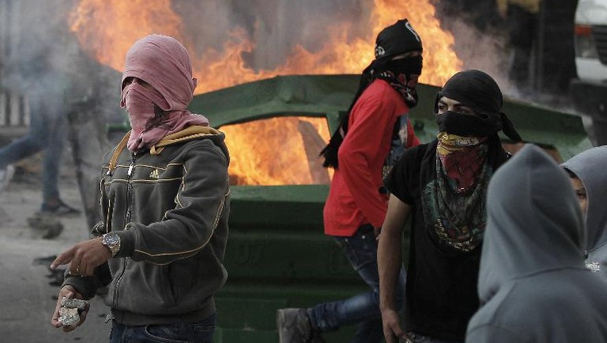 Des jeunes Palestiniens masqués lors de heurts avec des policiers israéliens au amp de Chouafat, à Jérusalem-Est, le 5 novembre 2014