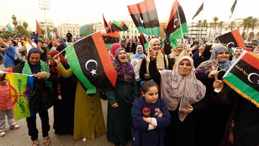 Des libyens agitent le drapeau national lors d'un rassemblement à Tripoli le 6 novembre 2014