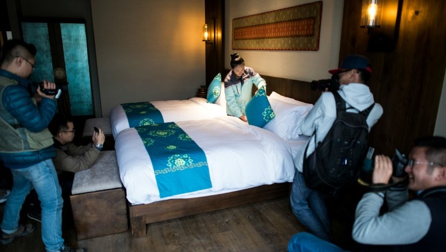 Des journalistes prennent des photos d'une chambre de l'hôtel Artel à Lulang, près de Nyingchi dans la région autonome du Tibet en Chine le 13 septembre 2016