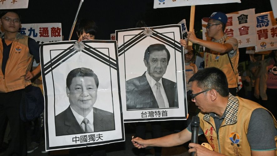 Un militant pour l'indépendance de Taïwan s'apprête à brûler des photos des dirigeants chinois et taïwanais, le 7 novembre 2015 à Taipei