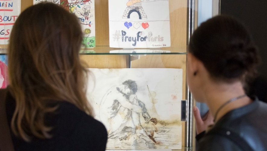 Des visiteurs regardent des dessins et des cartes réalisés après les attentats de Paris collectés par les Archives de Paris, à Paris le 17 septembre 2016