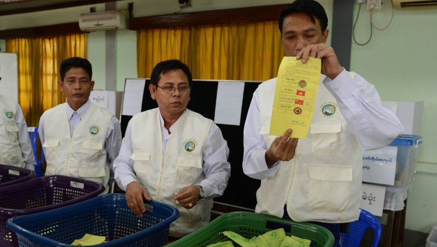 Des officiels montrent des bulletins de vote à Rangoun le 8 novembre 2015