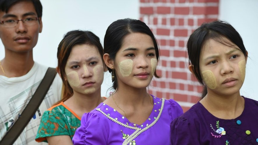 Des femmes birmanes portant le maquillage traditionnel thanaka font la queue pour voter à Rangoun le 8 novembre 2015