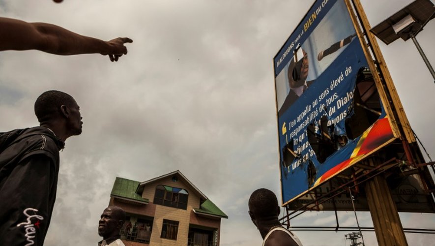 Des manifestants pointent du doigt un portrait endommagé du président Joseph Kabila, lors d'une manifestation de l'opposition à Kinshasa, le 19 septembre 2016
