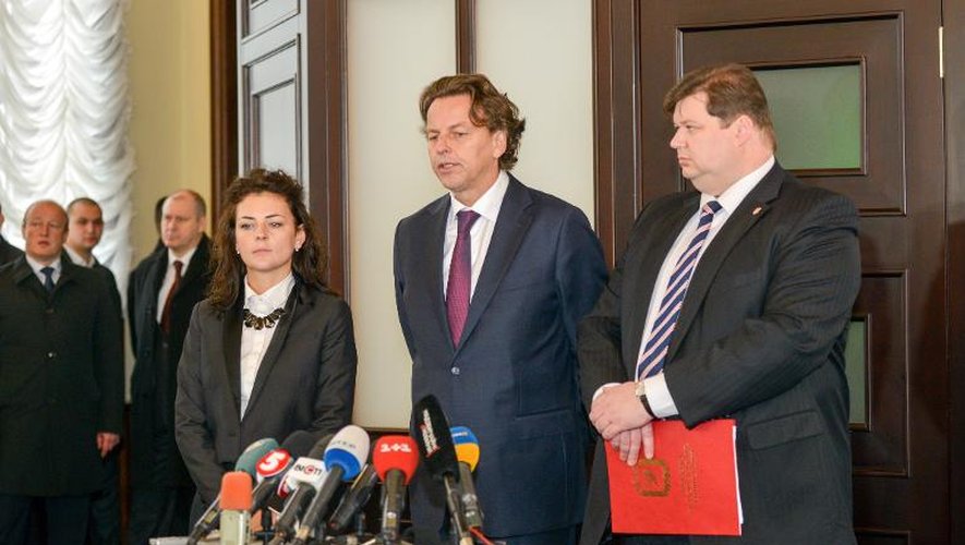 Le ministre néerlandais des Affaires étrangères, Bert Koenders (c) s'exprime devant les médias à Kharkiv, dans l'est de l'Ukraine, où des restes de passagers du vol MH17 abattu en juillet ont été transférés vers les Pays-Bas