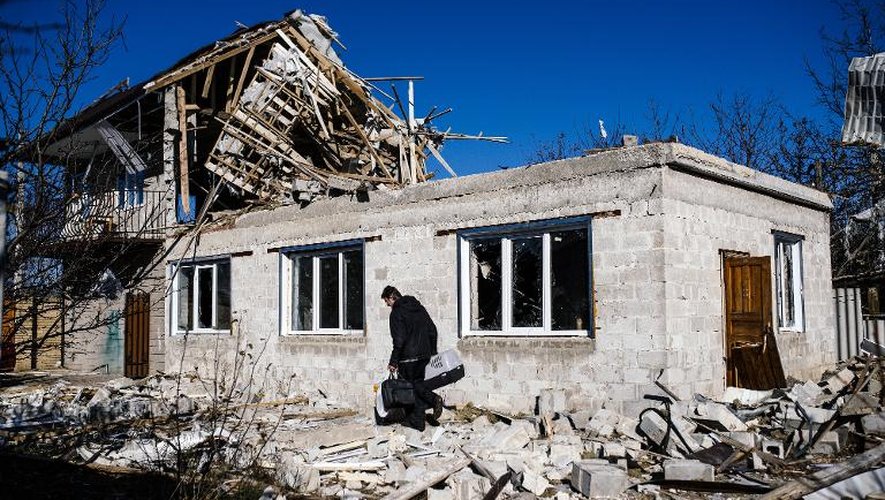 Un homme récupère quelques biens personnels dans sa maison détruite par les bombardements, près de Donetsk, dans l'est de l'Ukraine, le 6 novembre 2014