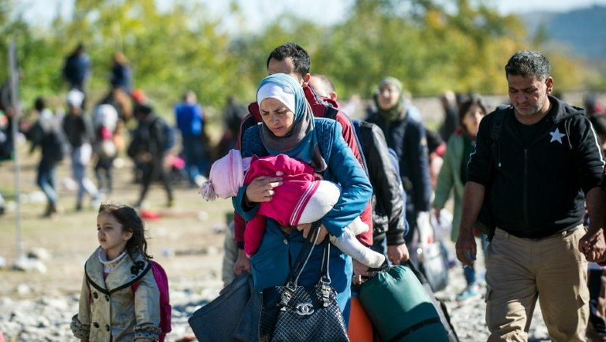 Des migrants franchissent la frontière entre la Grèce et la Macédoine le 9 novembre 2015 près de Gevgelija