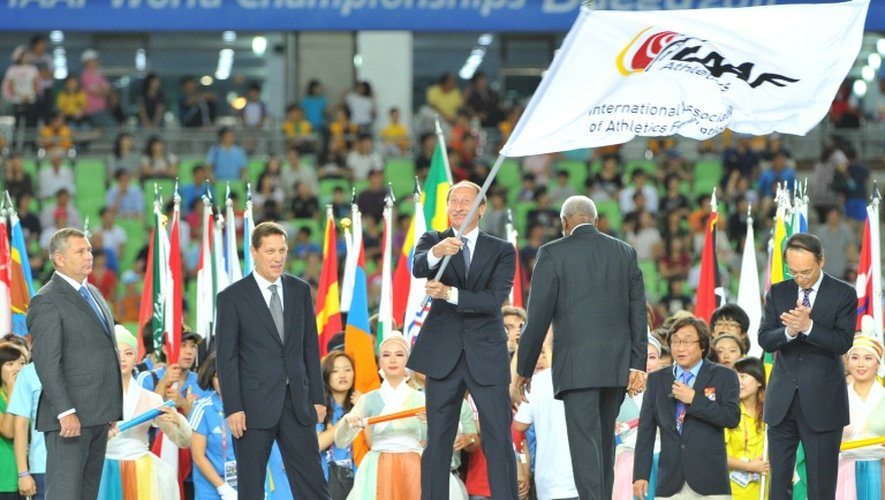 Valentin Balakhnichev, alors président de la Fédération russe d'Athlétisme, porte le drapeau de l'IAAF, le 4 septembre 2011 à Daegu, en Corée du Sud