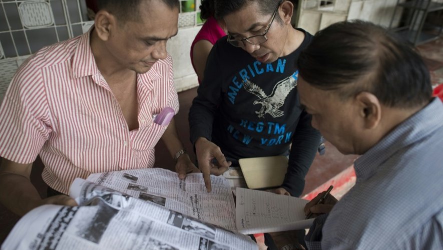 Les partisans d'Aung San Suu Kyi consultent les résultats des élections dans un quotidien le 10 novembre 2015 à Rangoun