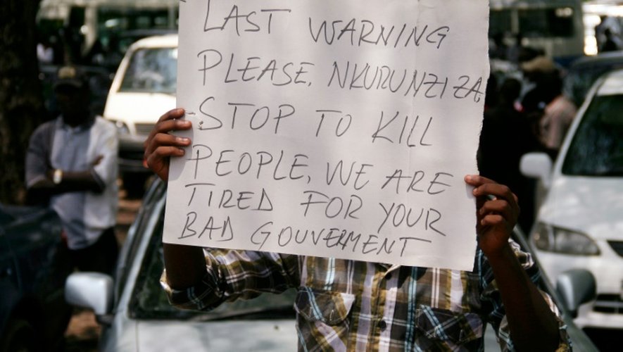 Un homme brandit une affiche visant le gouvernement burundais accusé de violences lors de funérailles, le 20 octobre 2015, à Bujumbura
