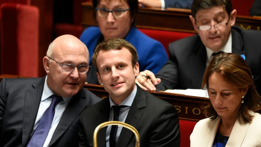 Le ministre français de l'Economie Emmanuel Macron (c) aux côtés de ses confrères des Finances Michel Sapin (g) et de l'Ecologie Ségolène Royal (d) à l'Assemblée nationale à Paris, le 10 novembre 2015