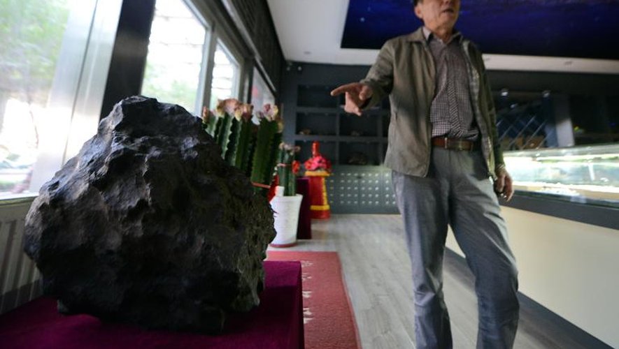 Tong Xianping, 50 ans, montre une des pièces maîtresses de sa collection de météorites, le 19 septembre 2014, dans son espace d'exposition à Urumqi, capitale de la vaste région désertique du Xinjiang, dans l'ouest de la Chine