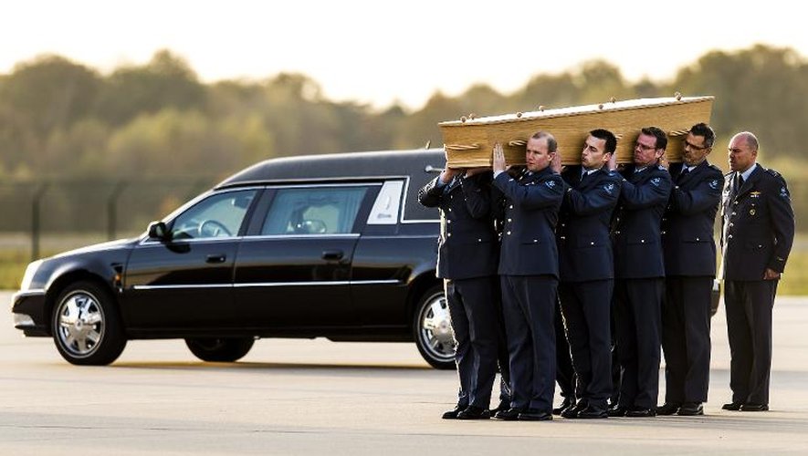 Des militaires néerlandais portent un cercueil contenant les restes des victimes du vol MH17, arrivés de Kharkiv, en Ukraine, le 8 novembre 2014 à l'aéroport d'Eindhoven, aux Pays-Bas