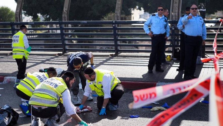 Des secouristes isréaliens nettoient le sang répandu sur le sol après l'agression au couteau d'un soldat par un Palestinien  à Tel-Aviv, peu de temps avant le même type d'agression contre une Israélienne près d'une colonie en Cisjordanie, le 10 novembre 2014