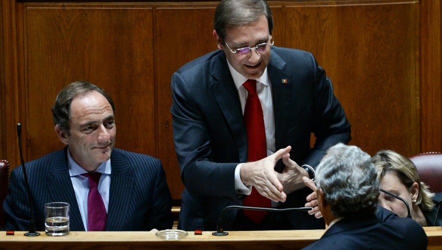 Le leader du parti socialiste portugais Antonio Costa (g) serre la main du Premier ministre Pedro Passos Coelho (c) à l'issue du vote au Parlement, le 10 novembre 2015 à Lisbonne
