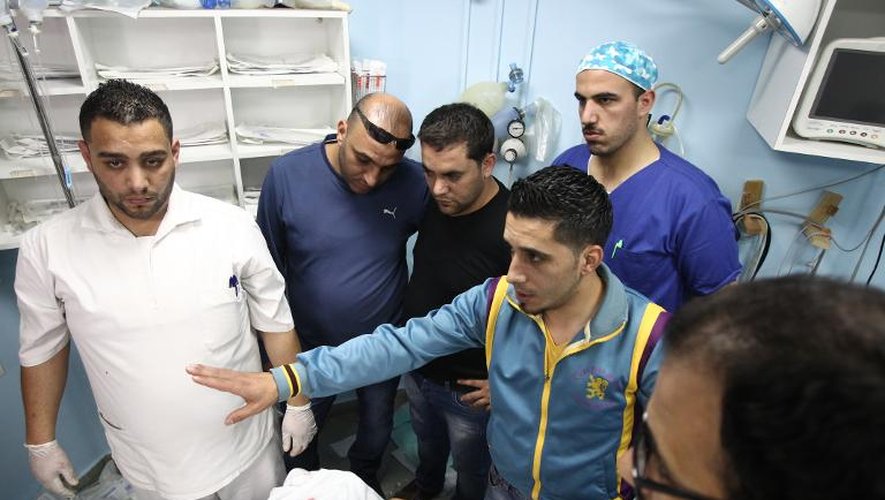 Des proches et du personnel médical entourent le corps du jeune palestinien Imad Jawabreh dans un hôpital à Hebron, le 11 novembre 2014