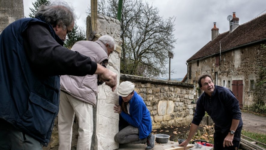 Des employés municipaux installent le nouveau monument aux morts de Parigny-la-Rose, dans le centre de la France, le 9 novembre 2015