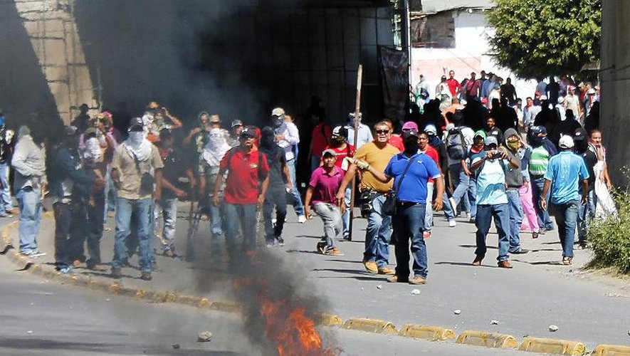 Des manifestants font face à la police lors d'un rassemblement pour obtenir justice dans la disparition de 43 étudiants d'Ayotzinapa, le 11 novembre 2014 à Chilpancingo, au Mexique