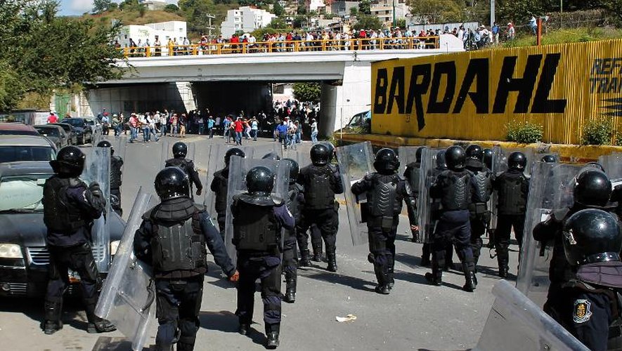 Des policiers antiémeutes se dirigent vers des manifestants rassemblés à Chilpancingo pour obtenir justice dans la disparition de 43 étudiants, le 11 novembre 2014 au Mexique