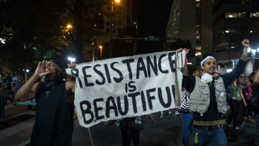 Des manifestants  brandissant des panneaux proclamant "Resistance is beautiful" ("La résistance est belle") défilent le 22 septembre 2016 dans la ville américaine de Charlotte