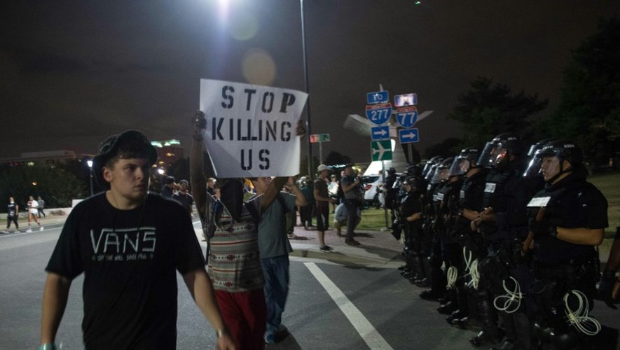 Des manifestants  brandissant des panneaux proclamant "Stop killing us" ("Arrêtez de nous tuer") défilent le 22 septembre 2016 dans la ville américaine de Charlotte