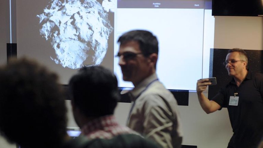Des scientifiques observent une photo transmise par l'Agence spatiale européenne (ESA) du robot européen Philae, le 12 novembre 2014, au Centre national d'études spatiales (CNES) à Toulouse
