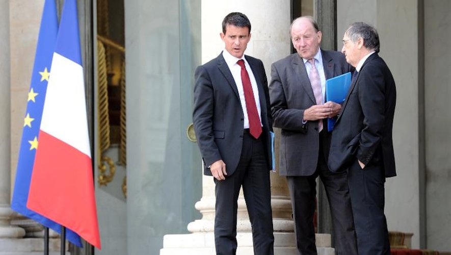 Le patron du Comité de pilotage dee l'EURO-2016 Jacques Lambert (c) échange avec le premier ministre Manuel Valls (g) et le président de la Fédération Noël le Graët à l'Elysée, le 11 septembre 2014