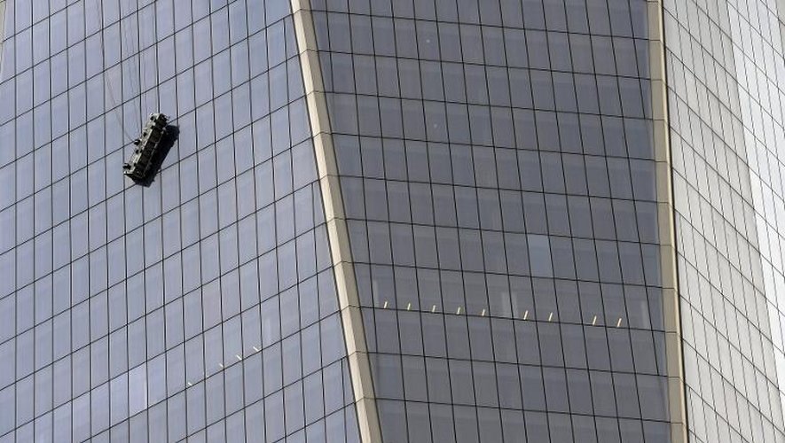Des laveurs de carreaux accrochés à leur nacelle au 69e étage de la tour 1 du World Trade Center à New York, le 12 novembre 2014