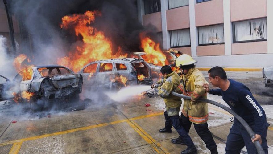 Des pompiers tentent d'éteindre des véhicules incendiés par des manifestants protestant contre la disparition de 43 étudiants, à Chilpancingo  dans l'Etat du Guerrero au Mexique le 12 novembre 2014