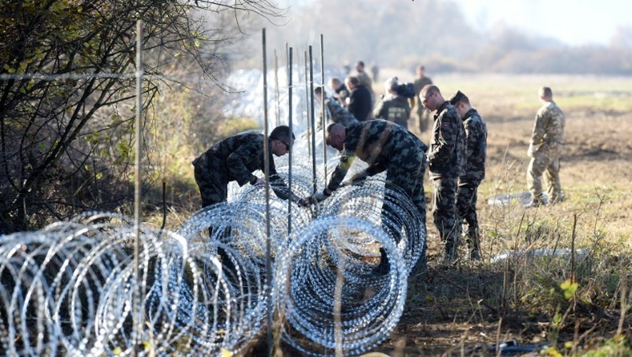 Des soldats slovènes installent une clôture en fil barbelé sur la frontière avec la Croatie, le 12 novembre 2015